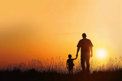 Silhouette Of A Father And Son Walking At Sunset