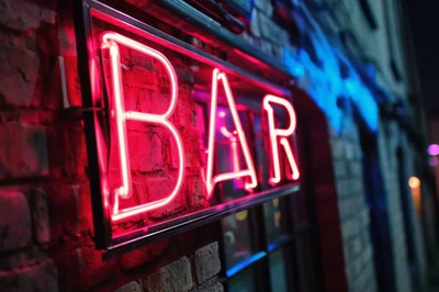 Glowing Red Neon Bar Sign On Brick Wall