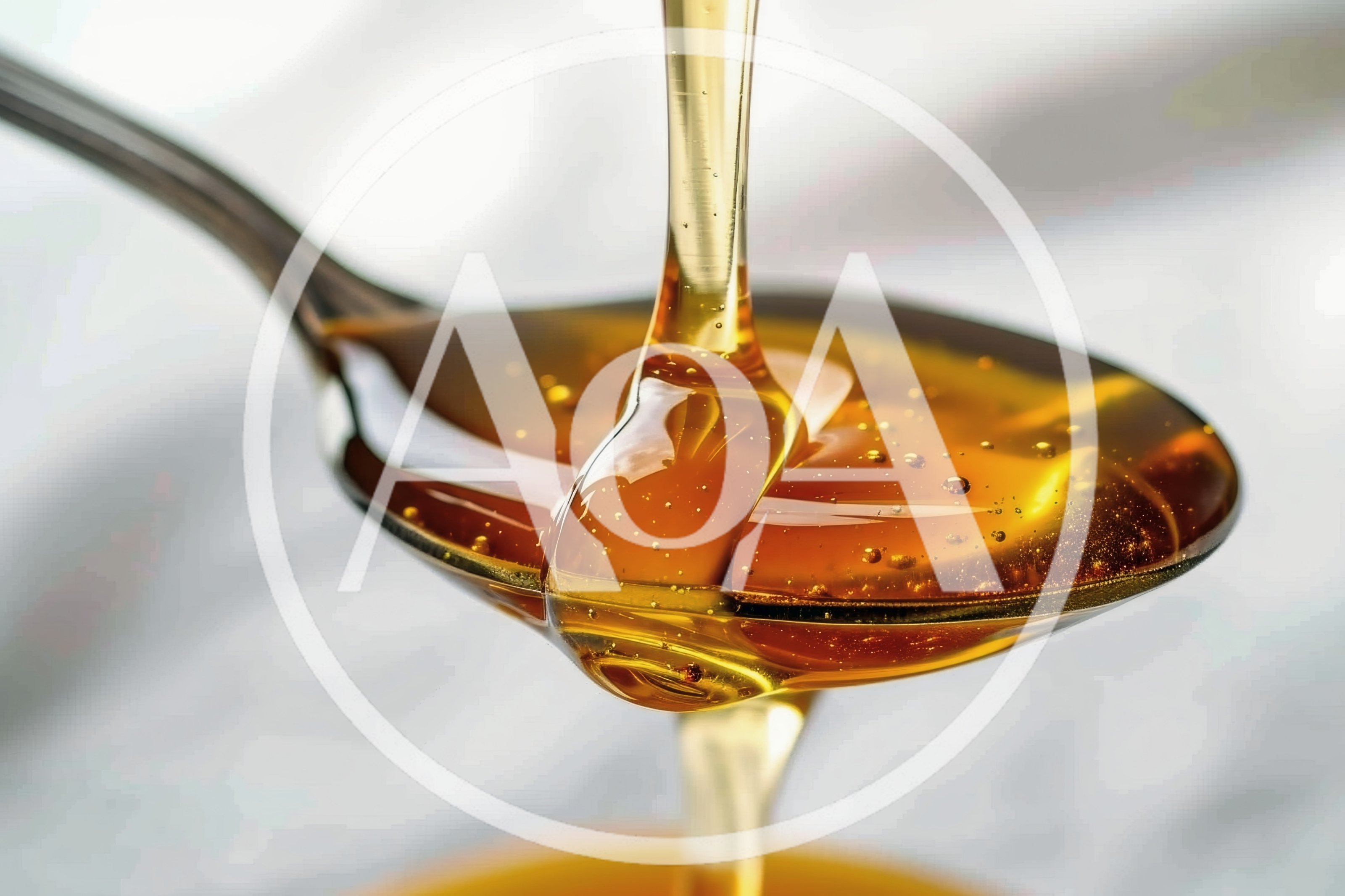 Golden Honey Pouring From A Metal Spoon