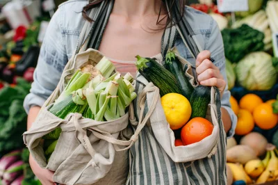 Woman Carrying Reusable Bags Filled With Fresh Produce