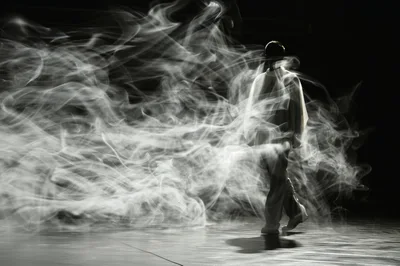 Dancer Moving Through Swirling Smoke On Stage