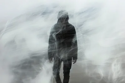 Silhouette Of A Person Walking Through Thick White Fog