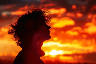 Silhouette Of A Young Man Against A Vibrant Sunset