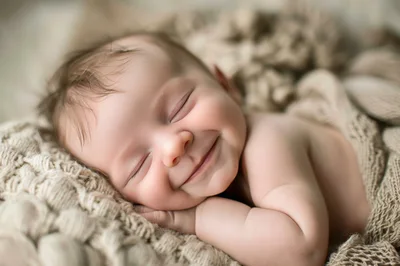Newborn Baby Sleeping Peacefully On A Knitted Blanket