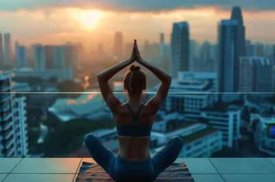 Woman Practicing Yoga On Rooftop At Sunset