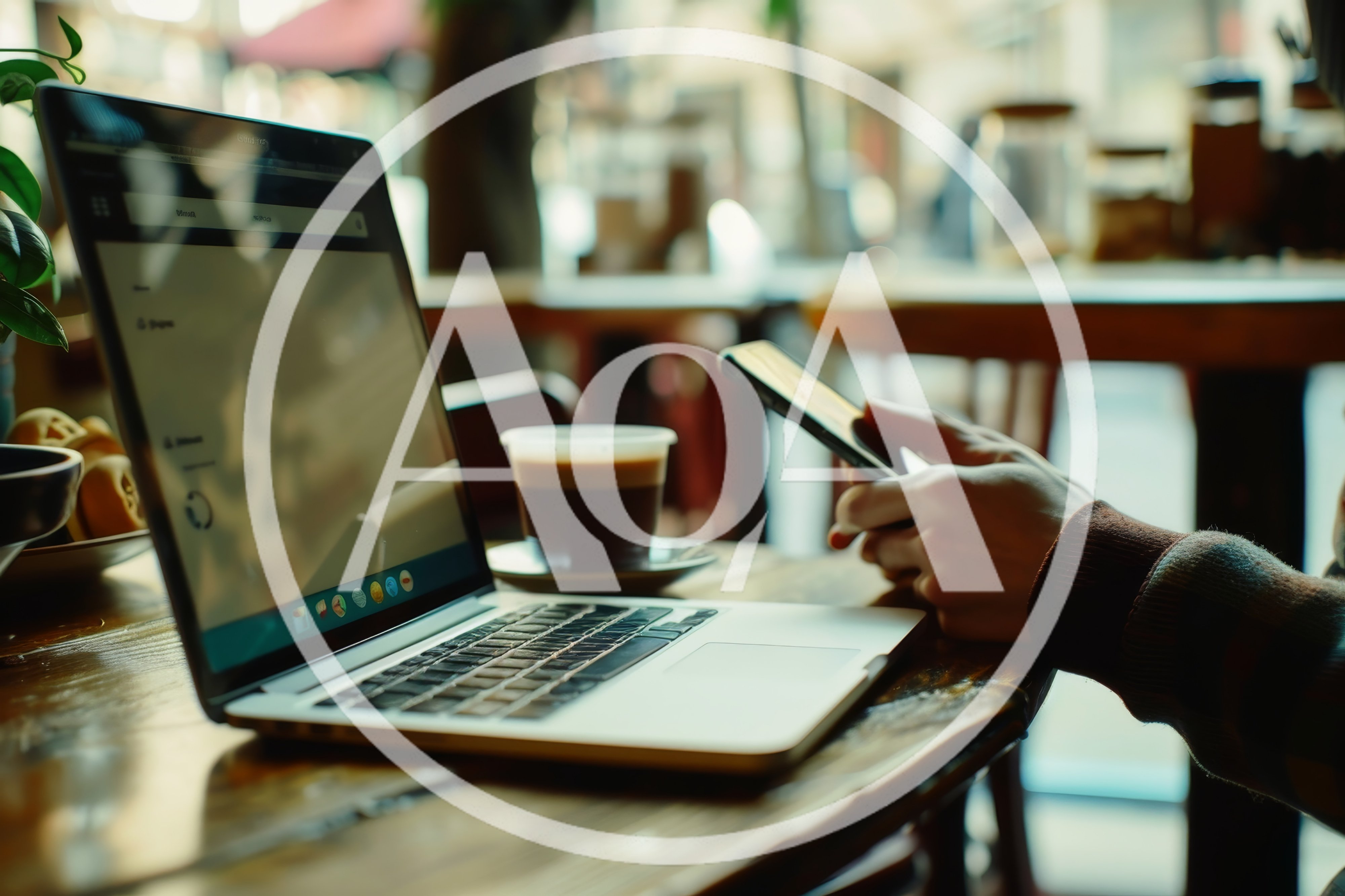 Person Using Smartphone While Working On Laptop In Cafe