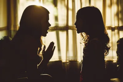 Silhouetted Sisters Talking In Front Of A Window