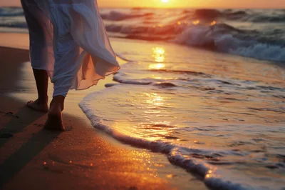 Woman Walking Barefoot Along The Beach At Sunset