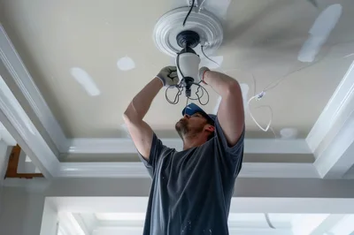 Electrician Installing A Ceiling Light Fixture