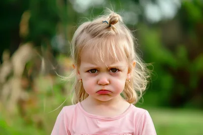 Portrait of a Grumpy Little Girl Outdoors