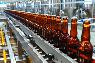 Amber Beer Bottles Moving Along Industrial Conveyor Belt