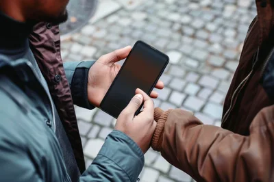 Two Men Sharing Information On A Smartphone