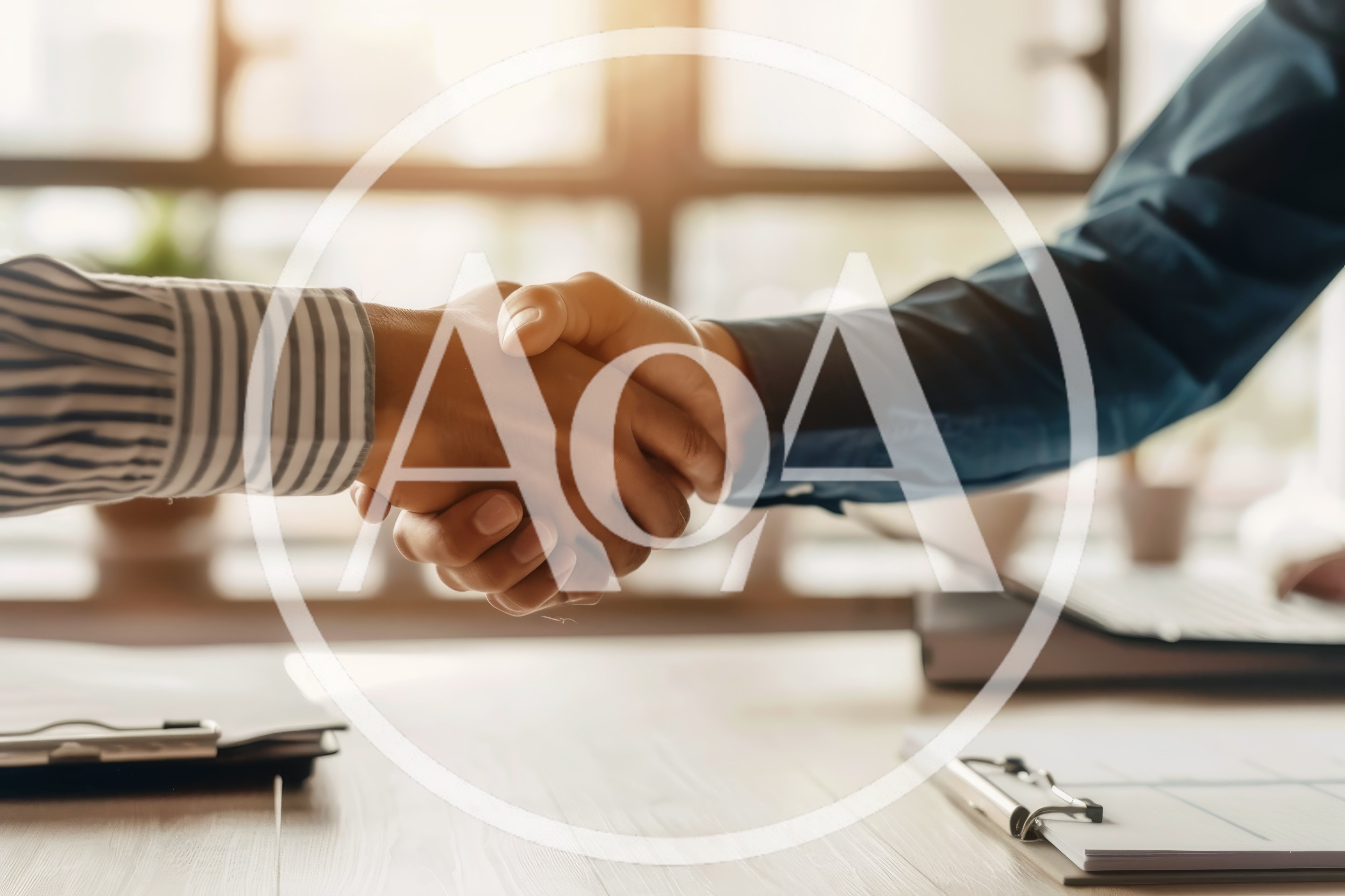 Business Professionals Shaking Hands Over Office Desk