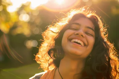 Young Woman Laughing Outdoors In Golden Hour Sunlight