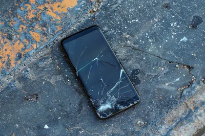Broken Smartphone Screen Lying On Cracked Concrete Ground