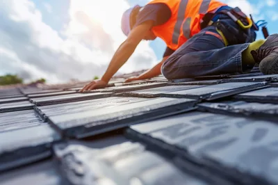 Construction Worker Installing Roof Tiles on Residential House
