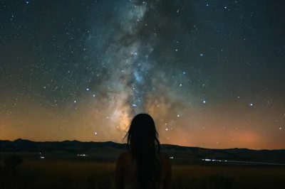 Woman Silhouetted Against The Milky Way Galaxy