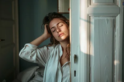Young Woman Relaxing In Sunlight By A Doorway