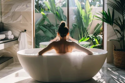 Woman Relaxing In A Luxury Bathtub With Tropical View