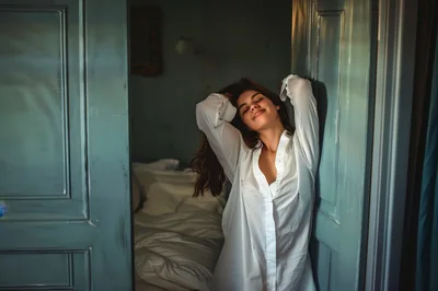 Young Woman Stretching In A White Shirt