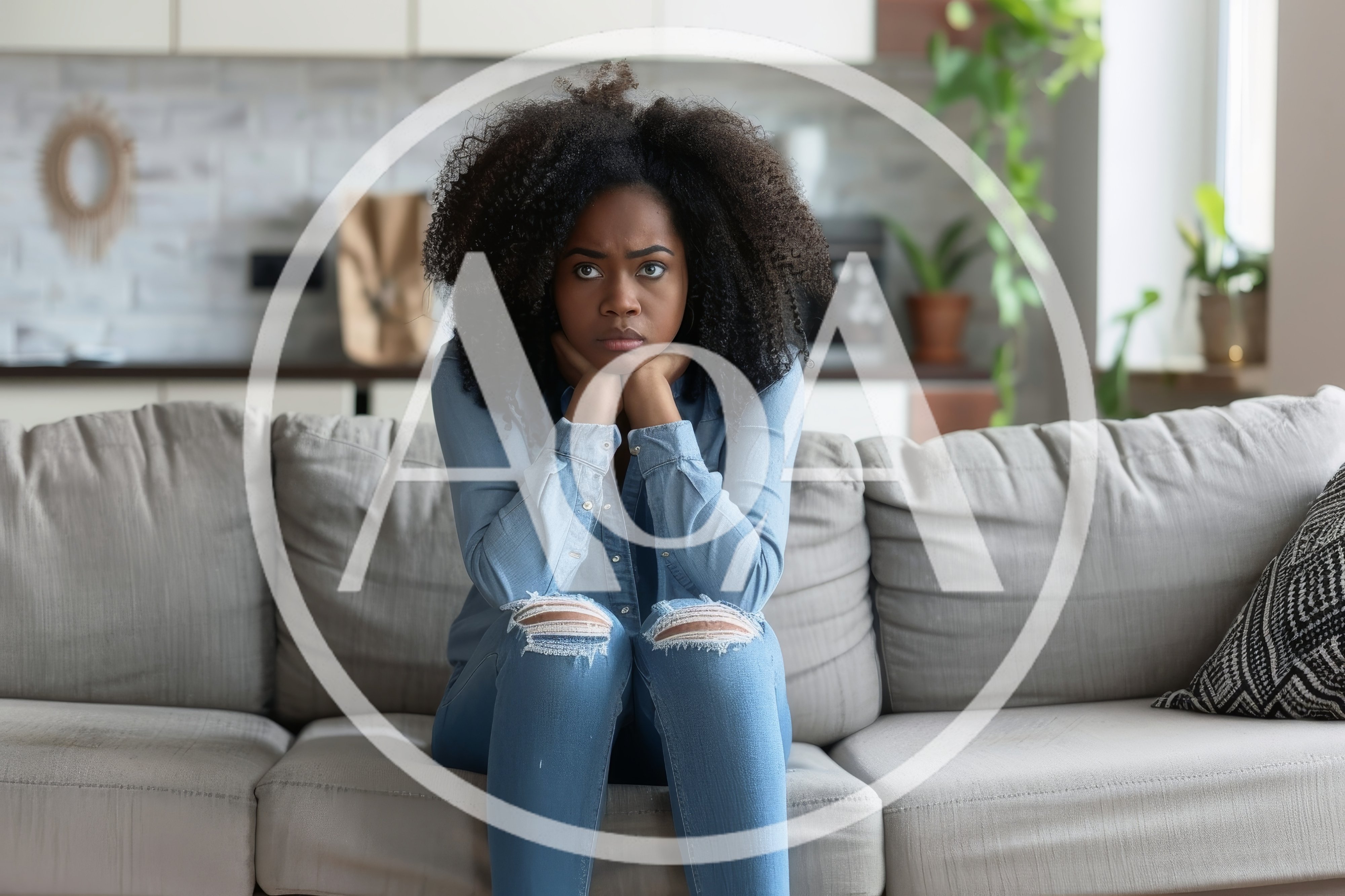 Pensive Young Woman Sitting On A Sofa