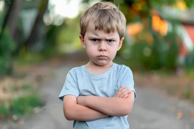 Angry Young Boy With Crossed Arms