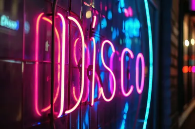 Neon Disco Sign Glowing In Nighttime City Setting