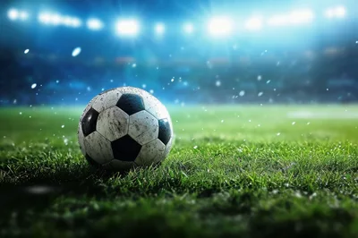 Dirty Soccer Ball Resting On Stadium Grass