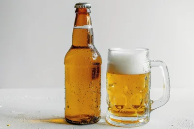 Brown Beer Bottle And Frothy Glass Mug