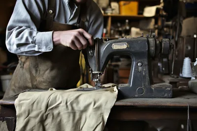 Artisan Using Vintage Sewing Machine In Workshop