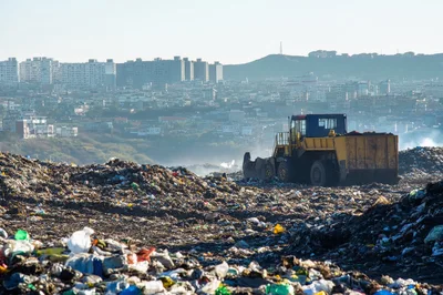Yellow Bulldozer Working At A Large Urban Landfill