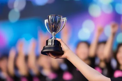 Person Holding A Shiny Silver Trophy Cup