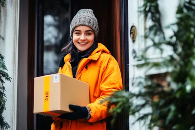 Delivery Person Holding Package At Front Door
