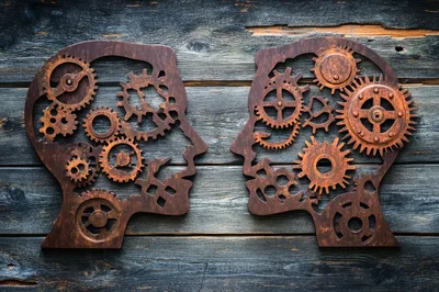 Two Metal Human Head Silhouettes With Internal Gears