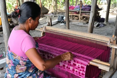 Indigenous Woman Weaving Traditional Textile on Wooden Loom