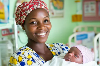 Happy Mother Holding Her Newborn Baby In Hospital