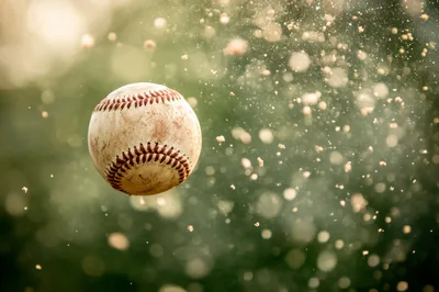 Dirty Baseball Flying Through Air With Dust Particles