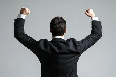 Businessman Celebrating Success With Arms Raised In Victory