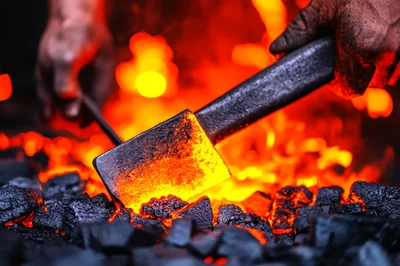 Blacksmith Heating Metal In A Coal Forge