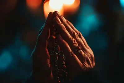 Close Up Of Hands Praying With A Rosary