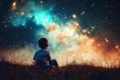Young Boy Sitting Alone Watching The Starry Night Sky