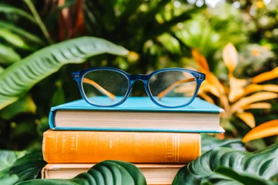 Blue Glasses Resting On A Stack Of Books