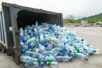 Plastic Bottles Spilling From A Large Industrial Dumpster