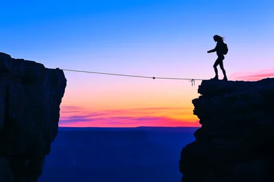 Silhouette Of A Hiker Balancing On A Tightrope