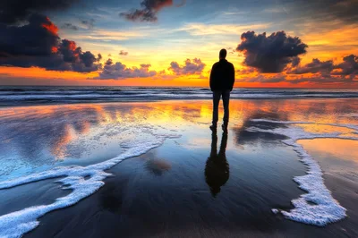 Man Standing Alone On Beach At Sunset