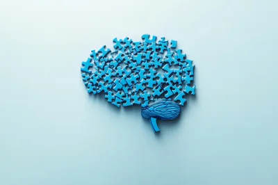Blue Puzzle Pieces Forming A Human Brain Shape