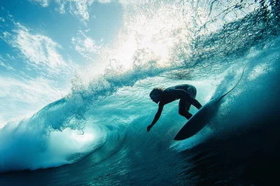 Surfer Riding Inside A Large Blue Ocean Wave