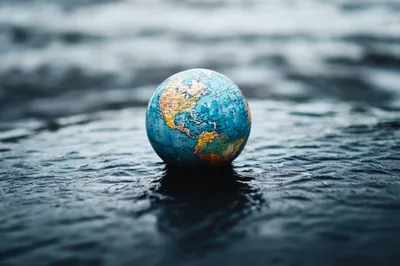Small Globe Resting On Wet Dark Surface