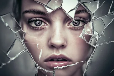 Close Up Portrait Of Woman Behind Shattered Glass
