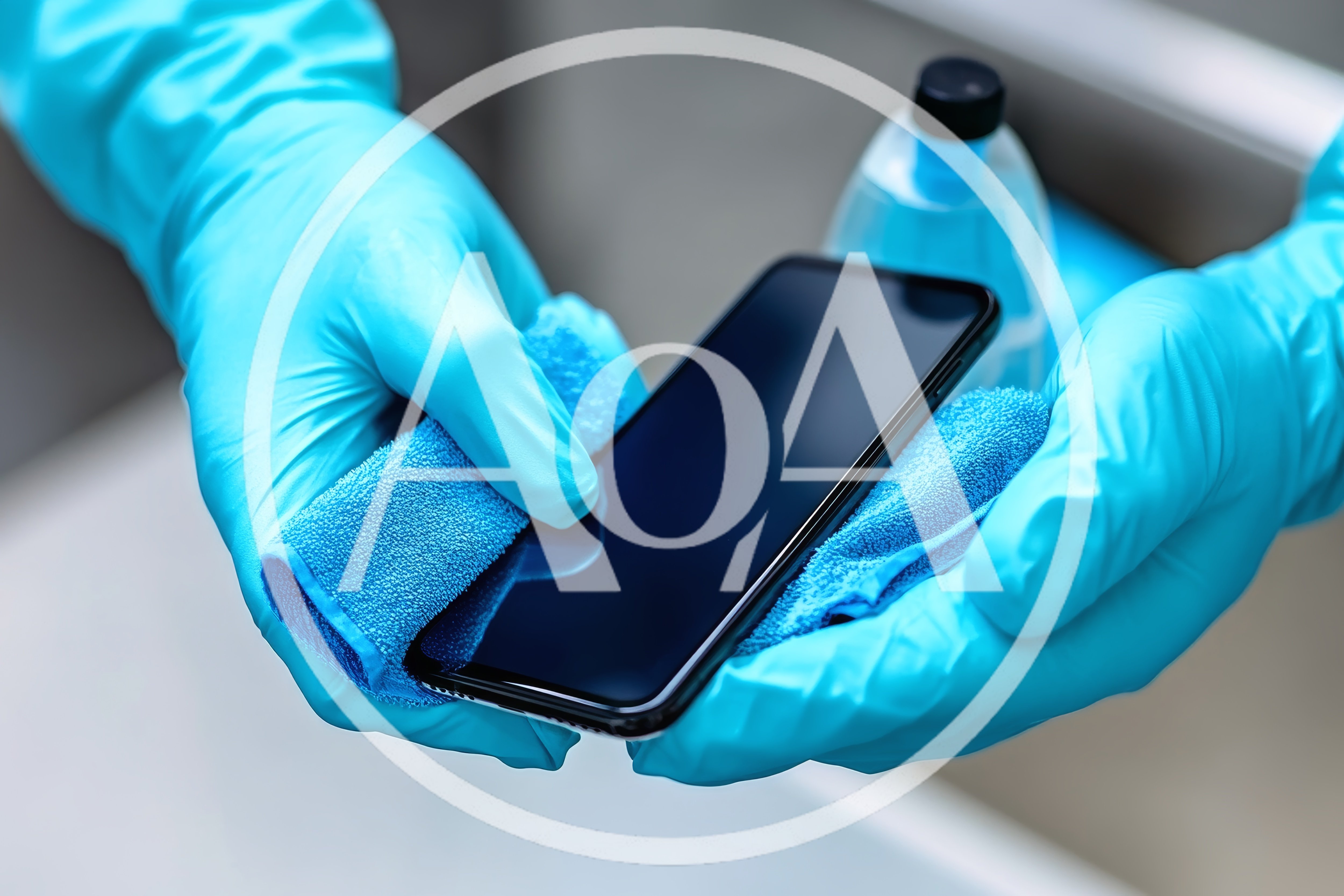 Person Cleaning Smartphone With Microfiber Cloth And Sanitizer
